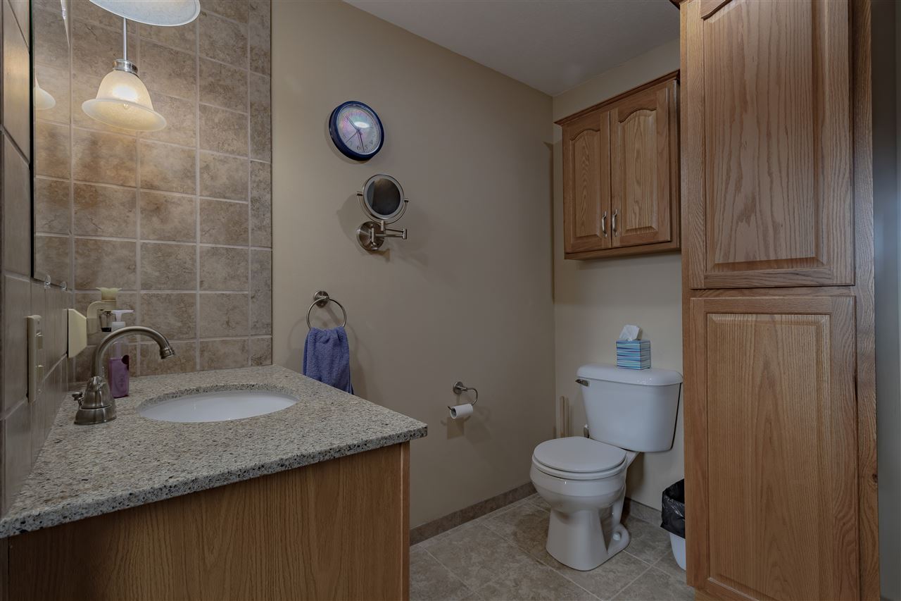9119 Montague Road Winnebago, IL 61088 - Photo 19 of 36 a bathroom with a granite countertop sink a toilet and a mirror