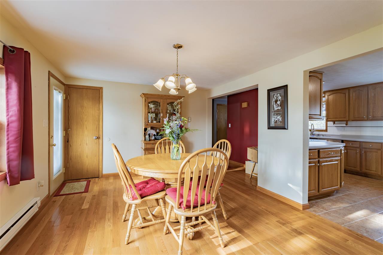 9119 Montague Road Winnebago, IL 61088 - Photo 6 of 36 a view of a dining room with furniture a chandelier and wooden floor
