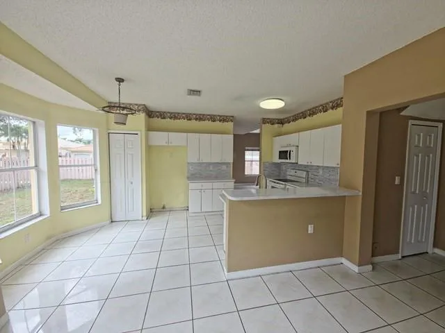 a view of kitchen with granite countertop cabinets