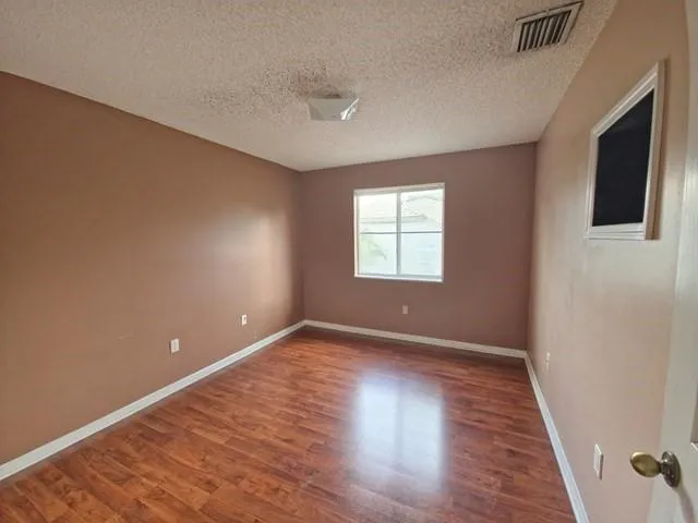 a view of an empty room with wooden floor