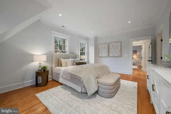 a spacious bedroom with a bed and wooden floor