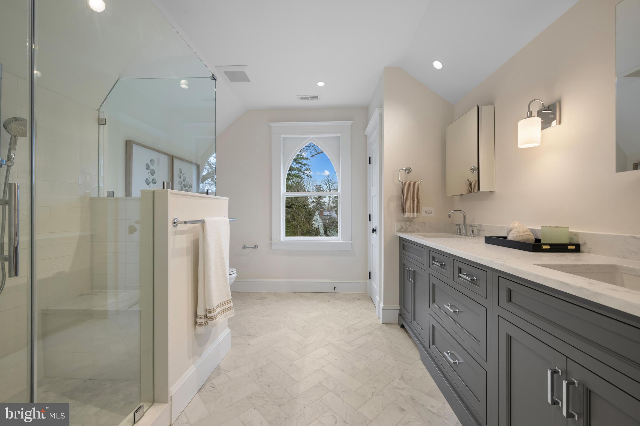 520 Woodlawn Road Baltimore, MD 21210 - Photo 26 of 39 a spacious bathroom with a double vanity sink a mirror a shower and a bathtub