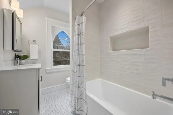 a bathroom with a bathtub a sink and a window