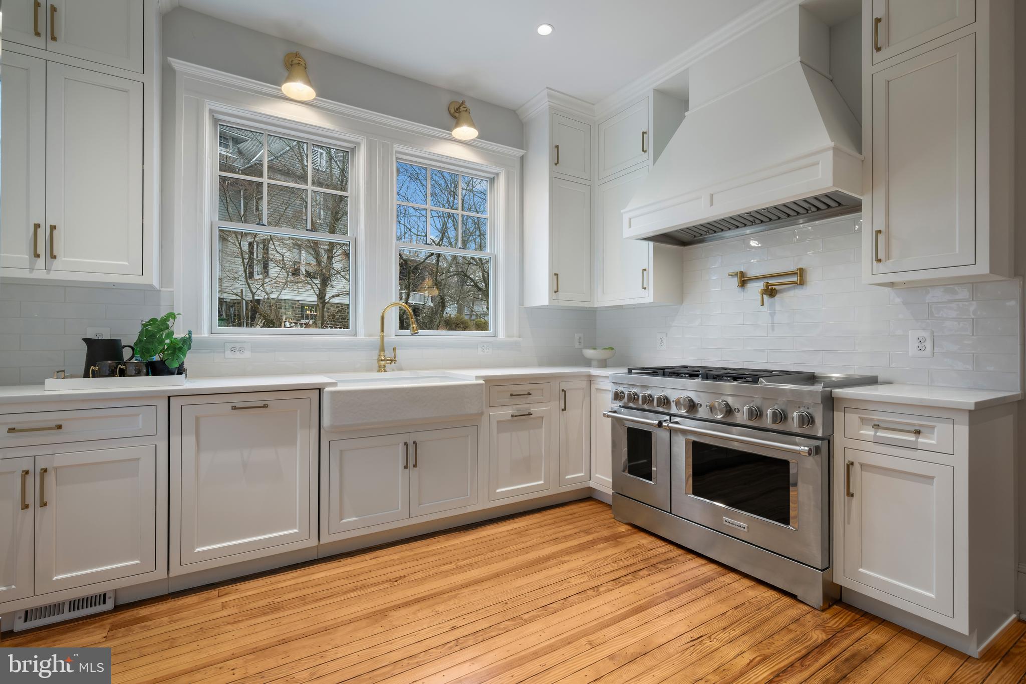 520 Woodlawn Road Baltimore, MD 21210 - Photo 9 of 39 a kitchen with stainless steel appliances white cabinets and wooden floors