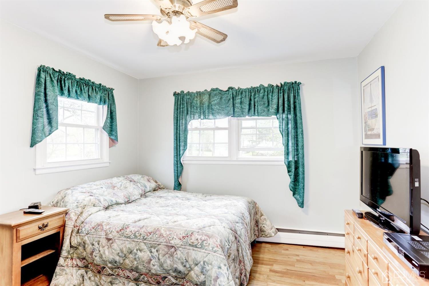 7 Chandler Road Edison, NJ 08820 - Photo 14 of 17 a bedroom with a bed and a flat tv screen on dresser