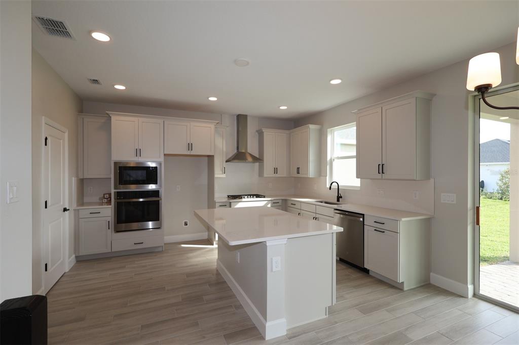 5261 High Line Drive St. Cloud, FL 34771 - Photo 14 of 39 a kitchen with stainless steel appliances granite countertop a sink and a stove top oven
