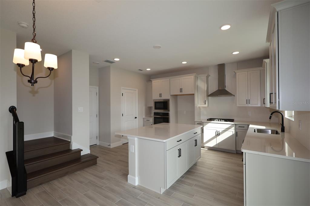 5261 High Line Drive St. Cloud, FL 34771 - Photo 15 of 39 a large kitchen with granite countertop a large counter top a sink stainless steel appliances and cabinets