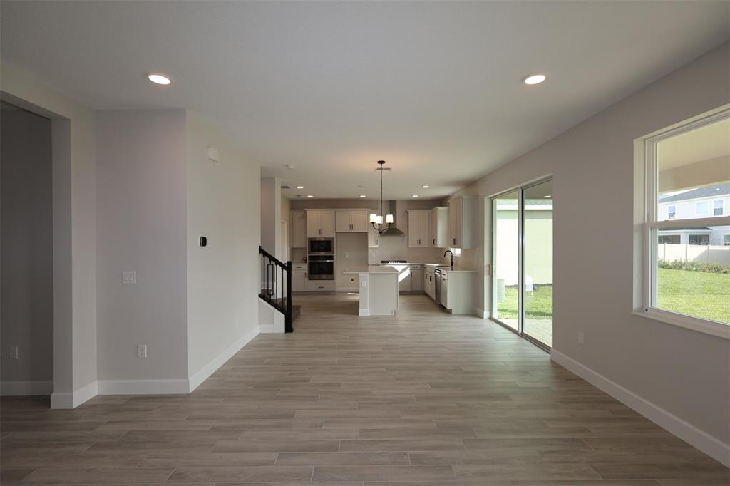 5261 High Line Drive St. Cloud, FL 34771 - Photo 18 of 39 a view of a living room and kitchen with furniture wooden floor and windows