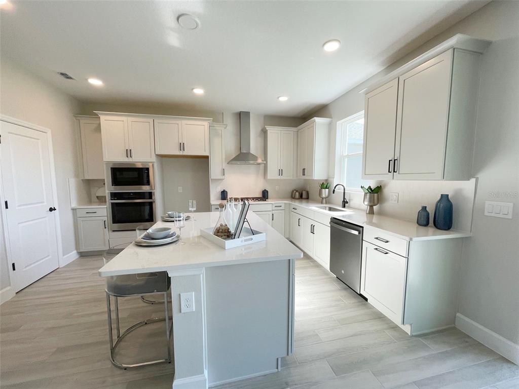 5261 High Line Drive St. Cloud, FL 34771 - Photo 3 of 39 a kitchen with white cabinets stove and kitchen island