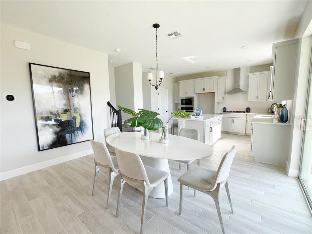 5261 High Line Drive St. Cloud, FL 34771 - Photo 6 of 39 a view of a dining room and livingroom with furniture wooden floor a chandelier