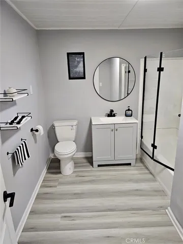 a spacious bathroom with a toilet a mirror and bathtub