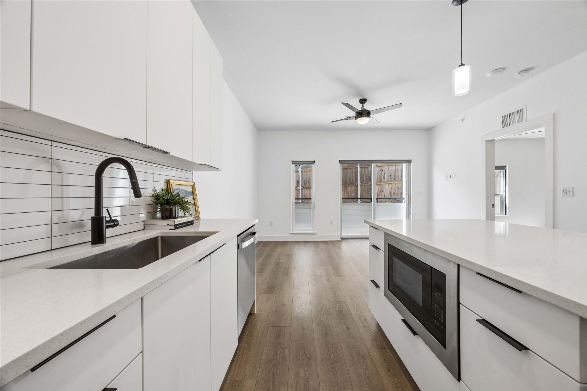 2220 Webberville Road, Unit 216 Austin, TX 78702 - Photo 6 of 26 Kitchen featuring white flat-panel cabinetry, white subway tile backsplash, and a matte black gooseneck faucet
