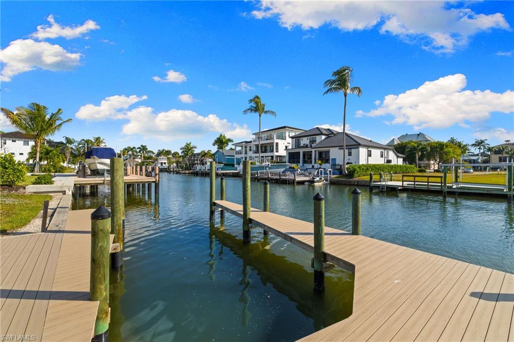 418 Seagull Avenue Naples, FL 34108 - Photo 26 of 36 a view of a lake with boats and a wooden bridge