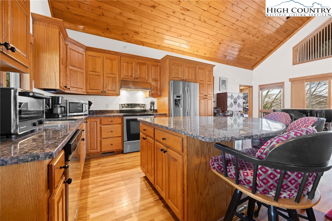 295 Supreme Golden Road Banner Elk, NC 28604 - Photo 12 of 40 a kitchen with stainless steel appliances granite countertop a sink a stove counter space and cabinets