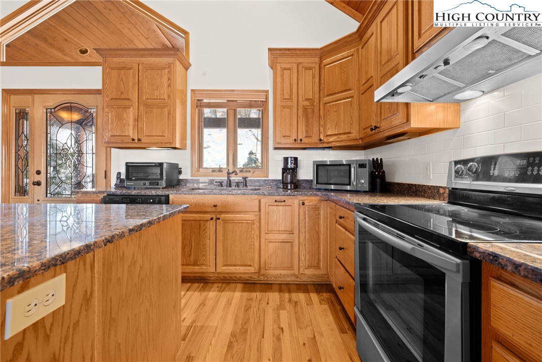 295 Supreme Golden Road Banner Elk, NC 28604 - Photo 14 of 40 a kitchen with stainless steel appliances granite countertop a stove a sink and a microwave