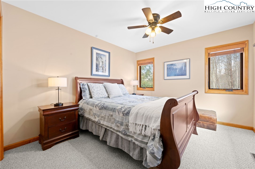 295 Supreme Golden Road Banner Elk, NC 28604 - Photo 19 of 40 a bedroom with a bed and a chandelier