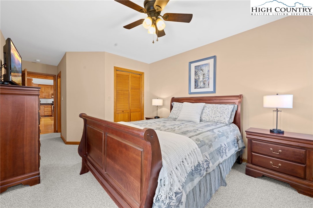 295 Supreme Golden Road Banner Elk, NC 28604 - Photo 20 of 40 a bedroom with a bed and a chandelier