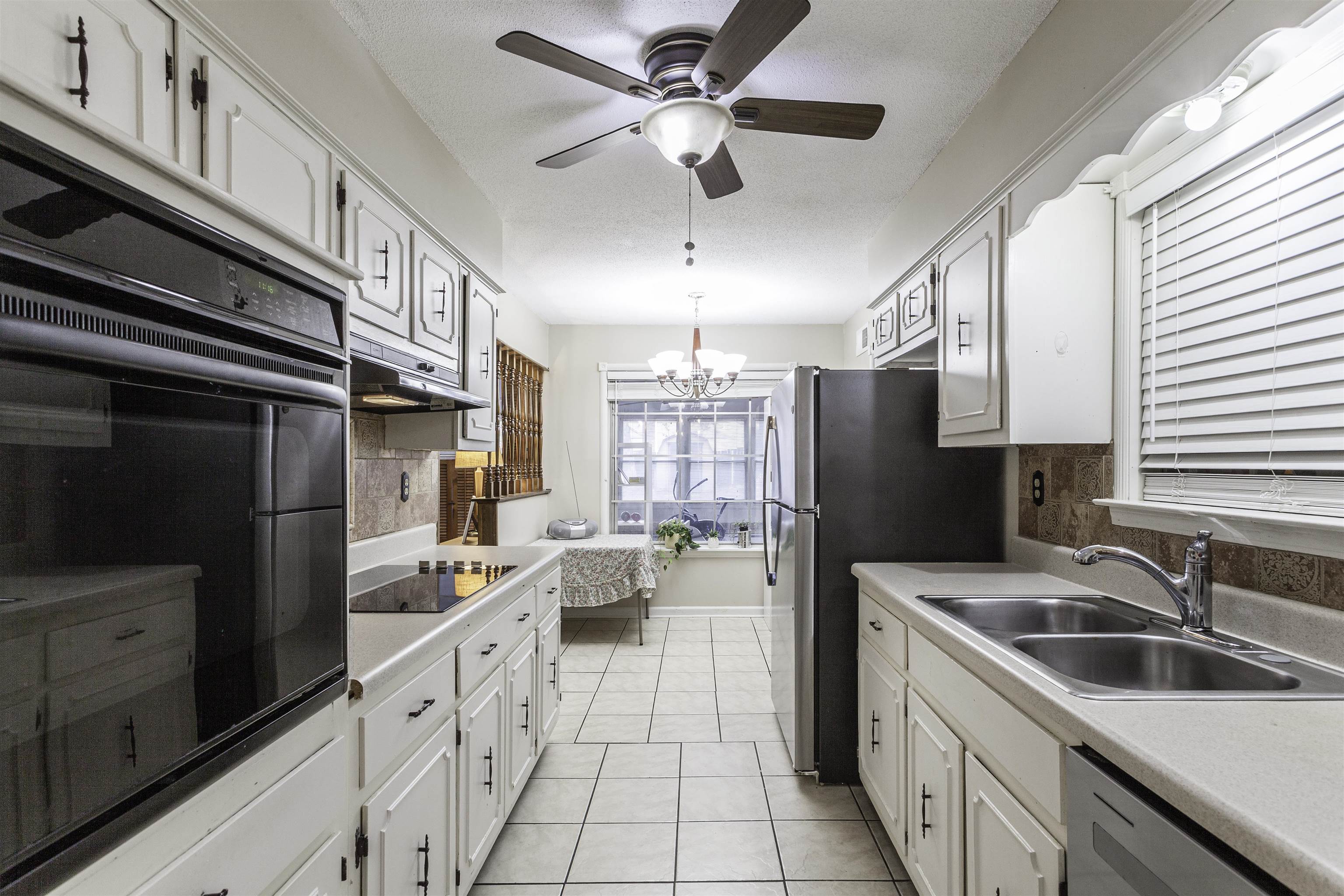 3462 Fox Meadows Road Memphis, TN 38115 - Photo 7 of 23 a kitchen with stainless steel appliances a sink a stove a refrigerator cabinets and a window