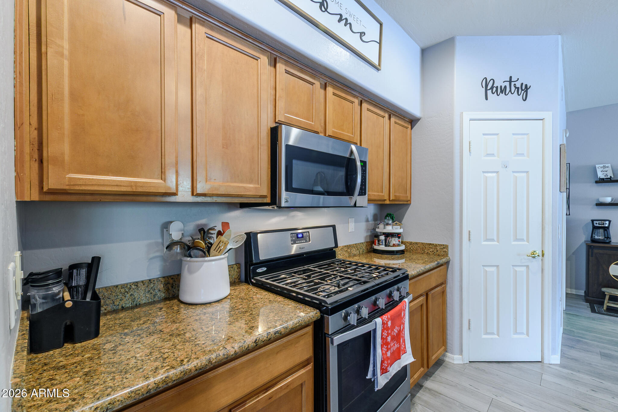 4521 West Moss Springs Road Anthem, AZ 85086 - Photo 16 of 35 a kitchen with stainless steel appliances granite countertop a stove a sink and a microwave