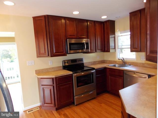 2402 Roth Road Edgewood, MD 21040 - Photo 1 of 27 a kitchen with wooden cabinets and a stove top oven
