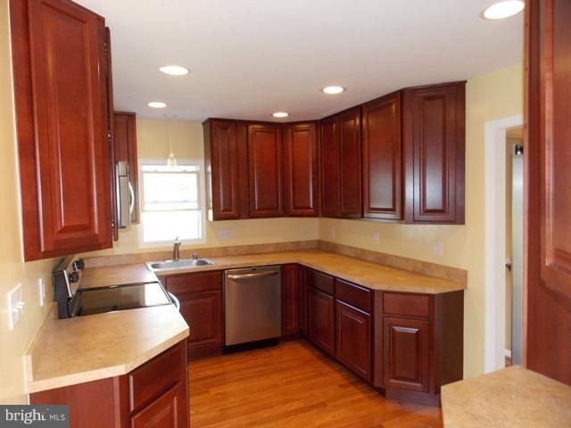 2402 Roth Road Edgewood, MD 21040 - Photo 16 of 27 a kitchen with wooden cabinets and sink