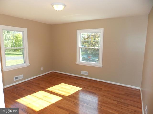 2402 Roth Road Edgewood, MD 21040 - Photo 6 of 27 an empty room with wooden floor and windows