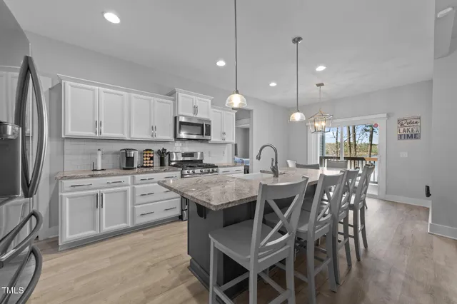 a kitchen with stainless steel appliances granite countertop a stove and a wooden cabinets
