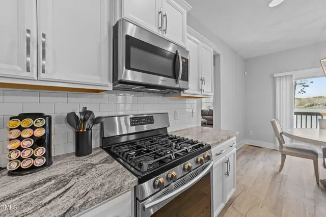 a large kitchen with stainless steel appliances granite countertop a lot of counter space a sink and appliances
