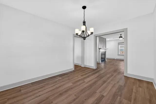a view of a big room with wooden floor and chandelier