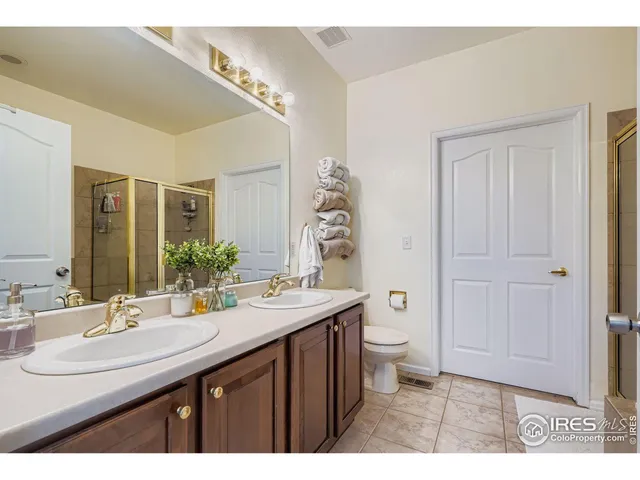 a bathroom with a sink a toilet and a large mirror