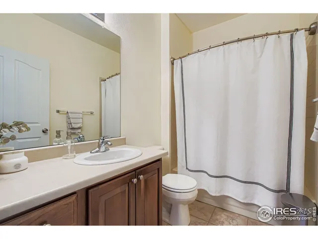 a bathroom with a sink a toilet a mirror and shower curtain