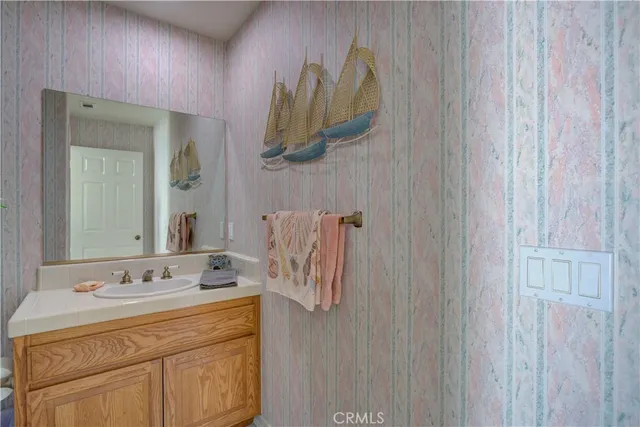 a bedroom with a bed a chandelier and dresser