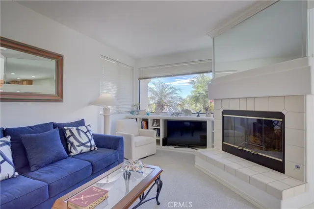 a living room with furniture a fireplace and a large window