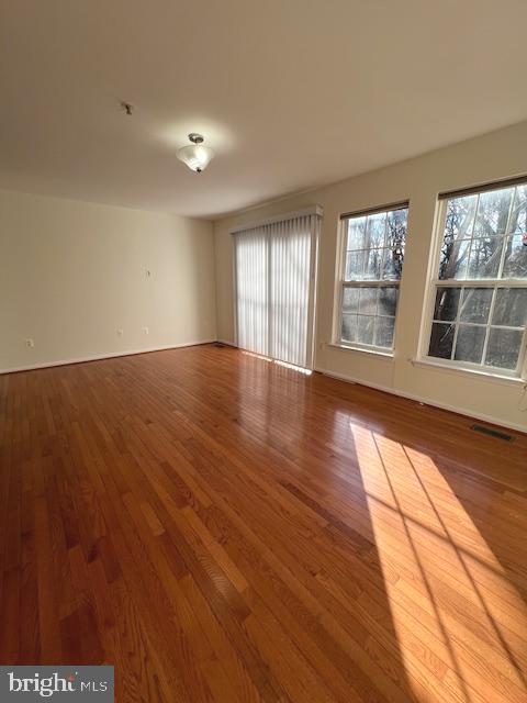 18704 Harmony Woods Lane Germantown, MD 20874 - Photo 7 of 21 a view of an empty room with wooden floor and a window