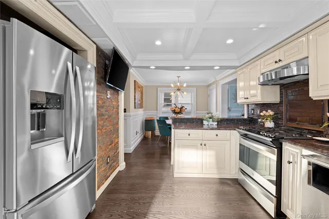 a kitchen with stainless steel appliances granite countertop a refrigerator a stove and a sink