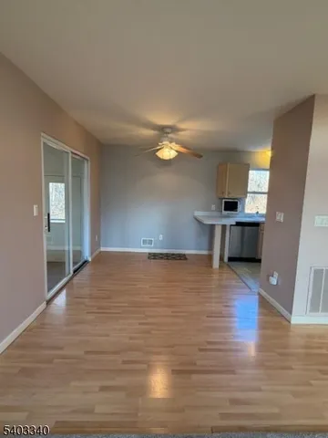 a view of empty room with kitchen and sink