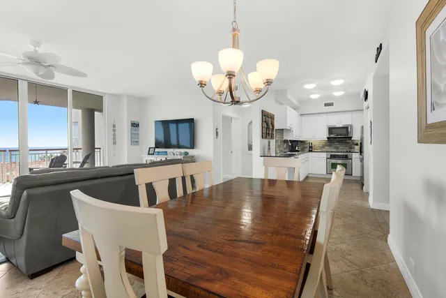 a dining room with wooden floor a chandelier a wooden table and chairs