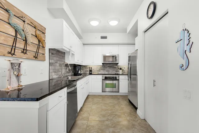 a kitchen with stainless steel appliances a refrigerator sink and microwave