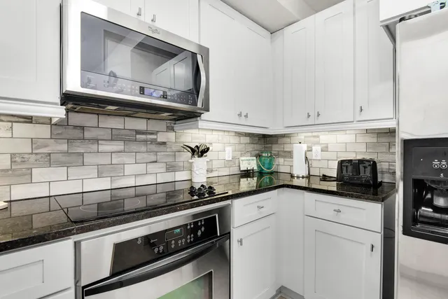 a kitchen with stainless steel appliances granite countertop a sink a stove and cabinets