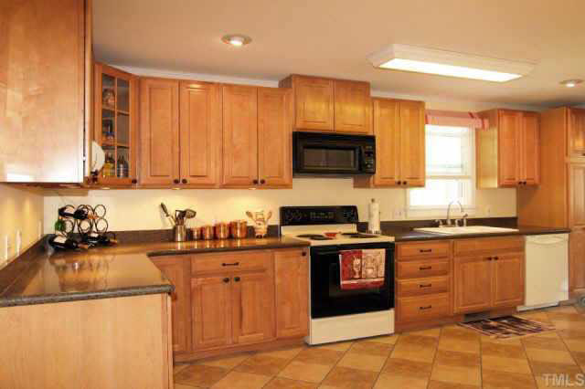 613 Mial Street Raleigh, NC 27608 - Photo 3 of 10 Maple cabinets, solid surface countertops Tiled Floor in kitchen and dining area