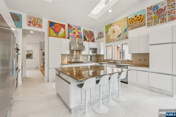 a kitchen with stainless steel appliances granite countertop a sink and a refrigerator