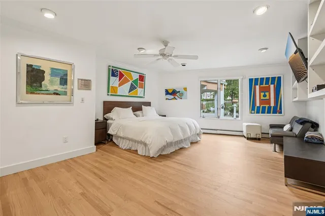 a bedroom with a bed couches and a flat tv screen