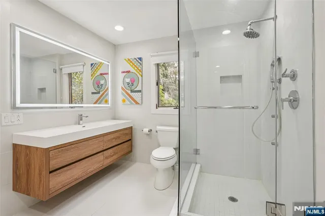 a bathroom with a sink a toilet and shower