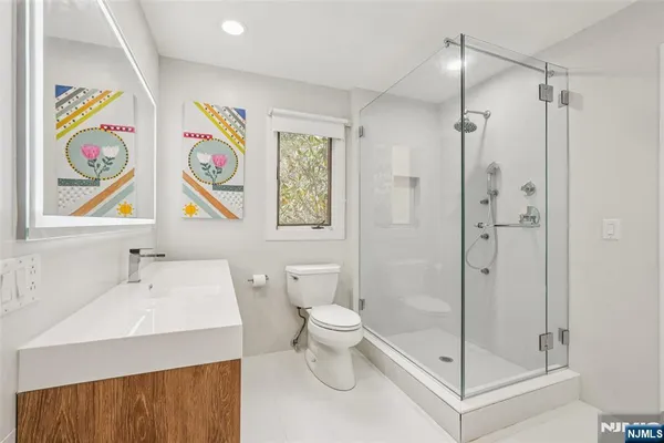 a bathroom with a sink a toilet and shower