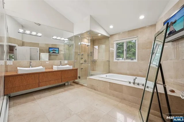 a bathroom with a double vanity sink a mirror and a bathtub