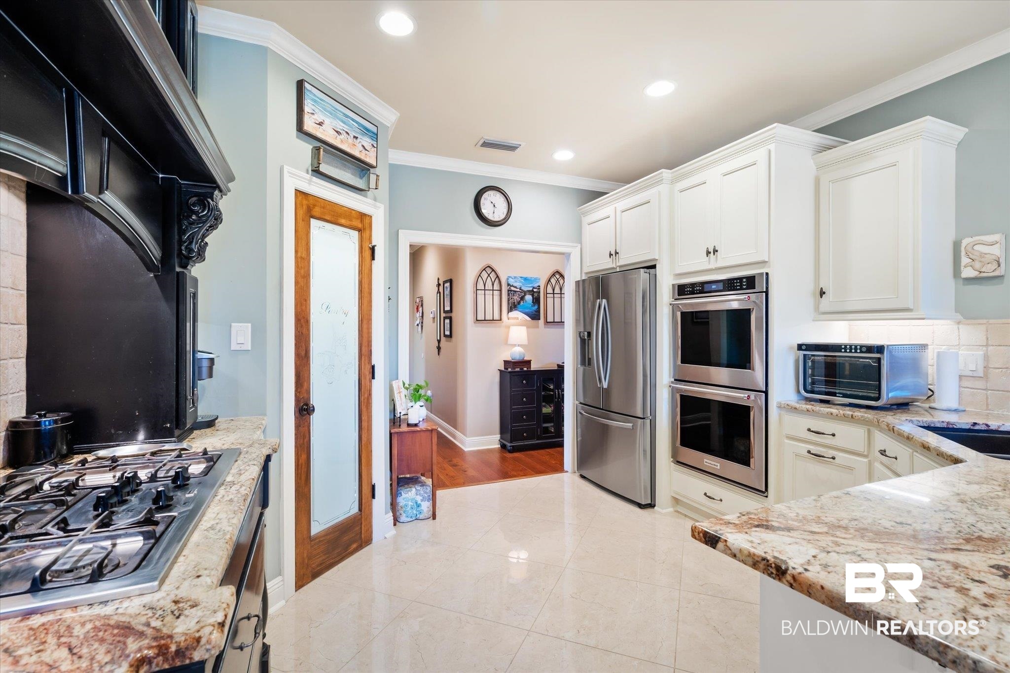 5683 Spring Landing Drive Theodore, AL 36582 - Photo 10 of 49 Kitchen with light hardwood / wood-style flooring, crown molding, stainless steel appliances, light stone counters, and white cabinets