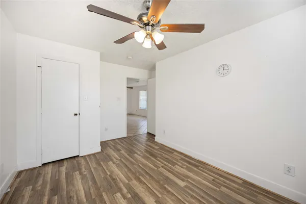 a view of a room with wooden floor and a ceiling fan