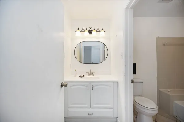 a bathroom with a sink mirror vanity and toilet
