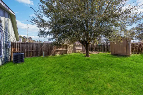 a view of a house with backyard and a tree