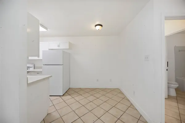 a view of a kitchen with white cabinets and wooden floor